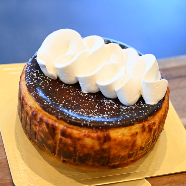 純生クリームでデコレーションされてバスクチーズケーキの写真